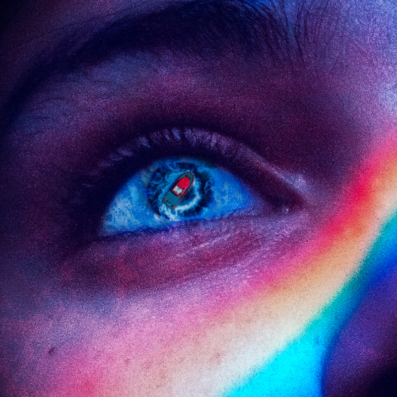 Close-up eye reflecting a tiny boat, rainbow flare